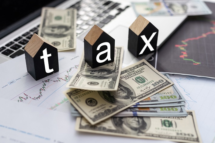 Tax text in wooden cubes and tax or vat form documents to complete Individual income tax return form for payment to Government. Calculation tax return in 2022 to 2023.